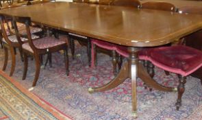 A modern reproduction mahogany twin pillar rounded rectangular dining table
