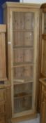 A modern pine slim bookcase with single door enclosing shelves CONDITION REPORTS
