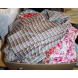 A box containing a collection of vintage 1950's tea and day dresses of various patterns