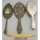 An embossed silver backed dressing table hand mirror decorated with cupid and psyche,