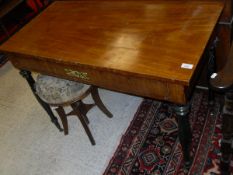 A Scandinavian mahogany writing table with single drawer on four ebonised turned supports to brass