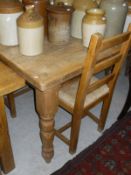 A rectangular pine dining table with turned legs,