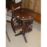 A 20th Century mahogany centre table with octagonal top turned pedestal to galleried second tier