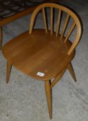 A light elm Ercol seated chair with low beech spindle back and beech turned supports