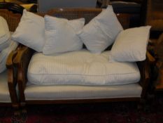 An early 20th Century beech framed bergere lounge suite to comprise of two seat sofa and two single