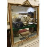 A large square wall mirror with shell moulded pediment in a gilt painted pine frame