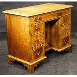 A 20th Century walnut desk with tooled green leather inset top above a single long drawer above the