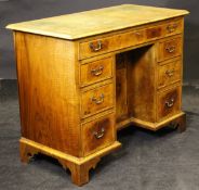A 20th Century walnut desk with tooled green leather inset top above a single long drawer above the