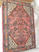 A pink ground Persian rug with all over floral decoration with cream ground spandrels decorated