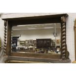 An oak framed overmantle mirror with barley twist supports,