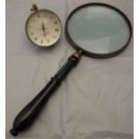 A large magnifying glass with ebonised handle and a bulls eye watch/clock*