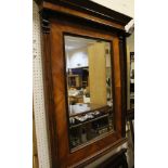 A mahogany wall mirror with shaped pediment and carved decoration with reeded supports with bevel