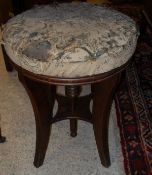 A Victorian adjustable piano stool with circular seat on moulded sabre supports