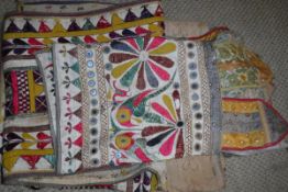 A bag containing four Indian door hangings of various colours,