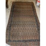 A Caucasian tribal rug in a camel ground central field with repeating hook motifs to a stepped