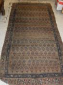 A Caucasian tribal rug in a camel ground central field with repeating hook motifs to a stepped
