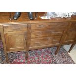 An Eastern hardwood sideboard with three central drawers flanked by single drawer and cupboard door,