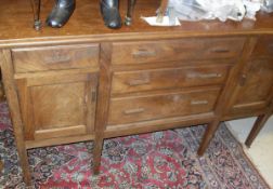 An Eastern hardwood sideboard with three central drawers flanked by single drawer and cupboard door,