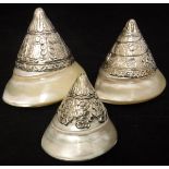 A graduated set of three white metal mounted shell ornaments of conical form