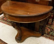 A Victorian mahogany demi lune side table on single carved cabriole front support united to the