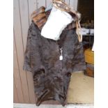 A brown fur coat with mink trim and a bag containing various bags,