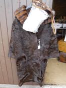 A brown fur coat with mink trim and a bag containing various bags,