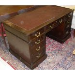 An early 20th Century mahogany kneehole desk with insert top over three frieze drawers on two banks