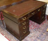 An early 20th Century mahogany kneehole desk with insert top over three frieze drawers on two banks