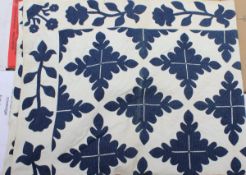 A 19th Century quilt with blue foliate style decoration on a white ground on a plain white back