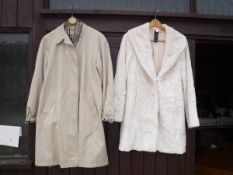 A beige Burberry mac and a Marc Cain faux fur cream coat
