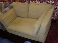 A pale gold two seat sofa on turned front legs to brass caps and castors CONDITION