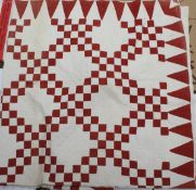 A 19th Century quilt with white and red design to front on a plain white backing