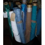 A box containing a large collection of assorted remnant rolls of fabric, mainly in blue,