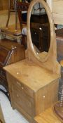 A late 19th early 20th Century pine dressing cupboard with oval mirror above single drawer and