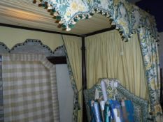 A modern mahogany framed four poster bed on four turned supports with green and yellow floral