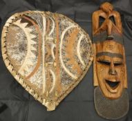 A 20th Century carved hardwood ethnic mask together with a painted hide shield and a short spear