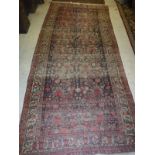 A Persian rug, the central panel set with all-over floral decoration on a dark blue ground,