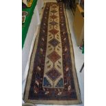 A Kazak runner with repeating lozenge and stylised medallions on a fawn ground,