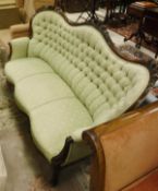 A Victorian three seat sofa in pale green button back upholstery,