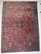 A Caucasian rug, the central panel set with all-over floral design on a red ground,
