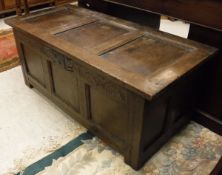 An oak coffer with panelled top with three panels to the front,