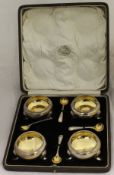 A cased set of four George V silver open salts of cauldron form with gilt-washed interiors and