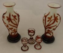 A pair of white ground vases with relief red flower on vine decoration,