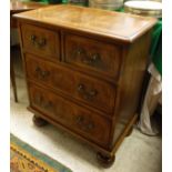 An oyster walnut and inlaid chest of two short over two long drawers to turned feet