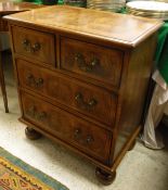 An oyster walnut and inlaid chest of two short over two long drawers to turned feet