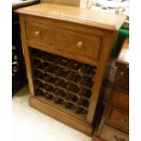 A burr oak and inlaid wine rack with applied moulded edge above a single drawer and space for 25