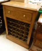 A burr oak and inlaid wine rack with applied moulded edge above a single drawer and space for 25