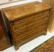 A walnut and feather banded bachelor's chest with fold-over top above four graduated drawers to