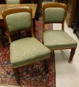 A set of four 19th Century oak framed dining chairs with green self patterned upholstered seat and