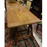 An Eastern hardwood rectangular topped table with cleated end supports, raised on folding trestles,